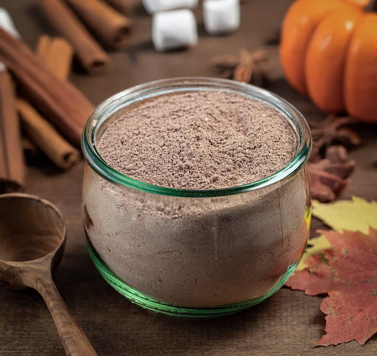 Pumpkin Spice Hot Cocoa Mix in a jar on a wooden table. 