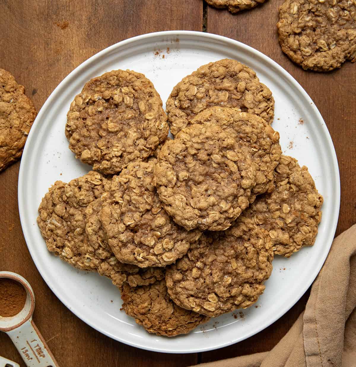 Pumpkin Spice Oatmeal Cookies on a white plate on a wooden table from overhead.