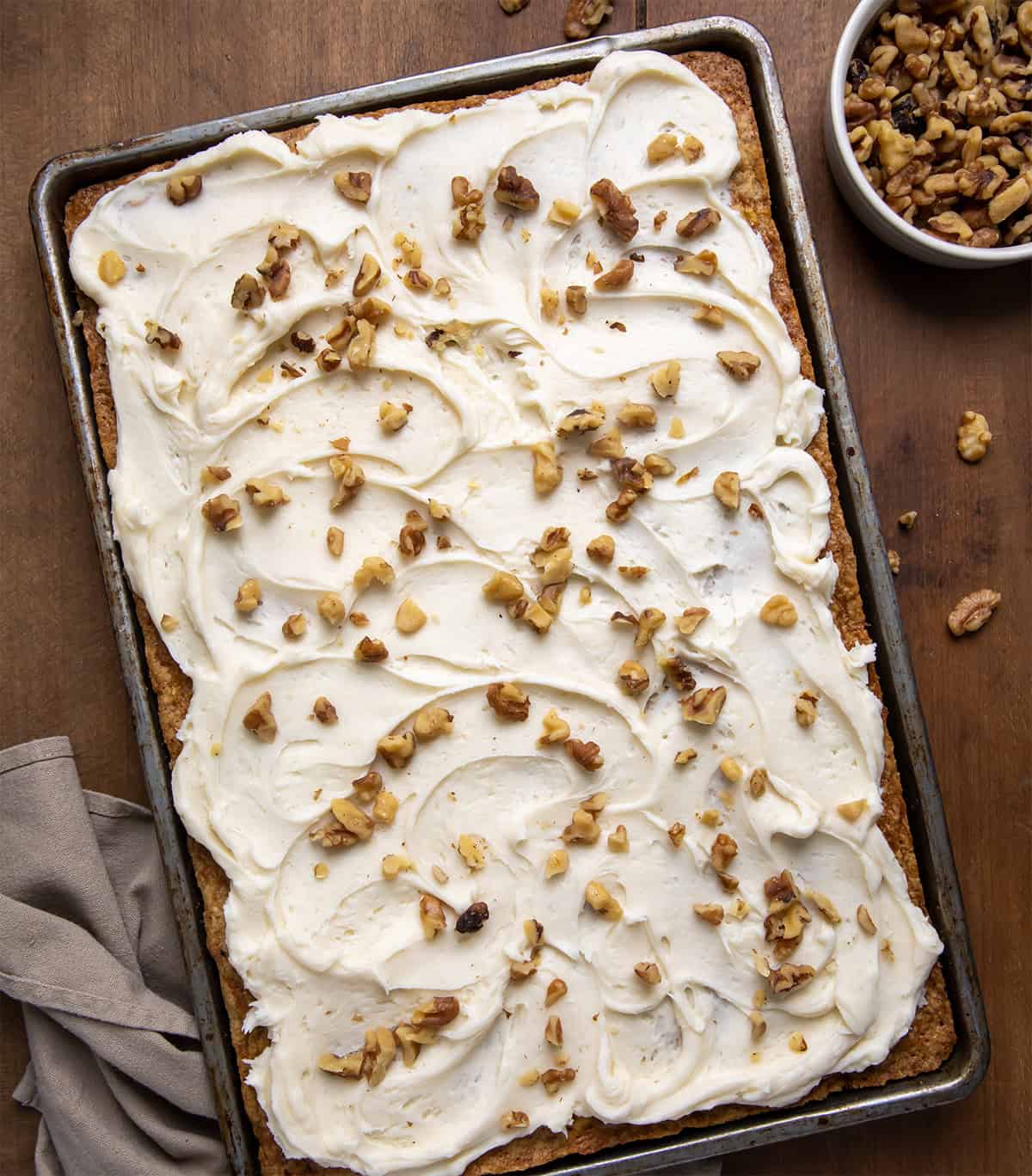 Sheet Pan Carrot Cake Bars on a wooden table from overhead.