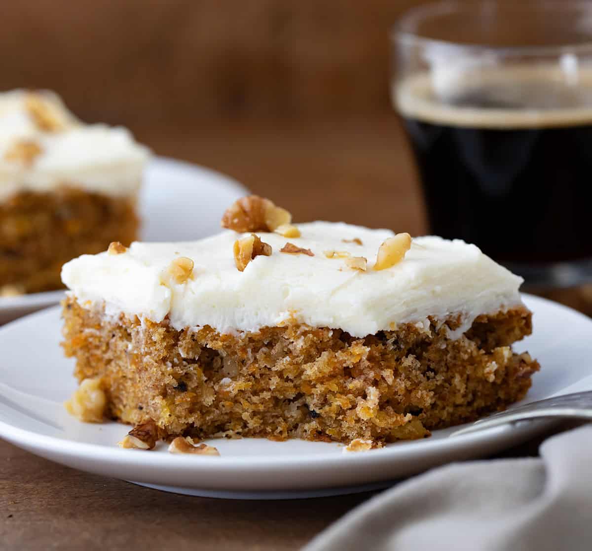 Sheet Pan Carrot Cake Bar with a bite taken out and fork resting on the white plate.