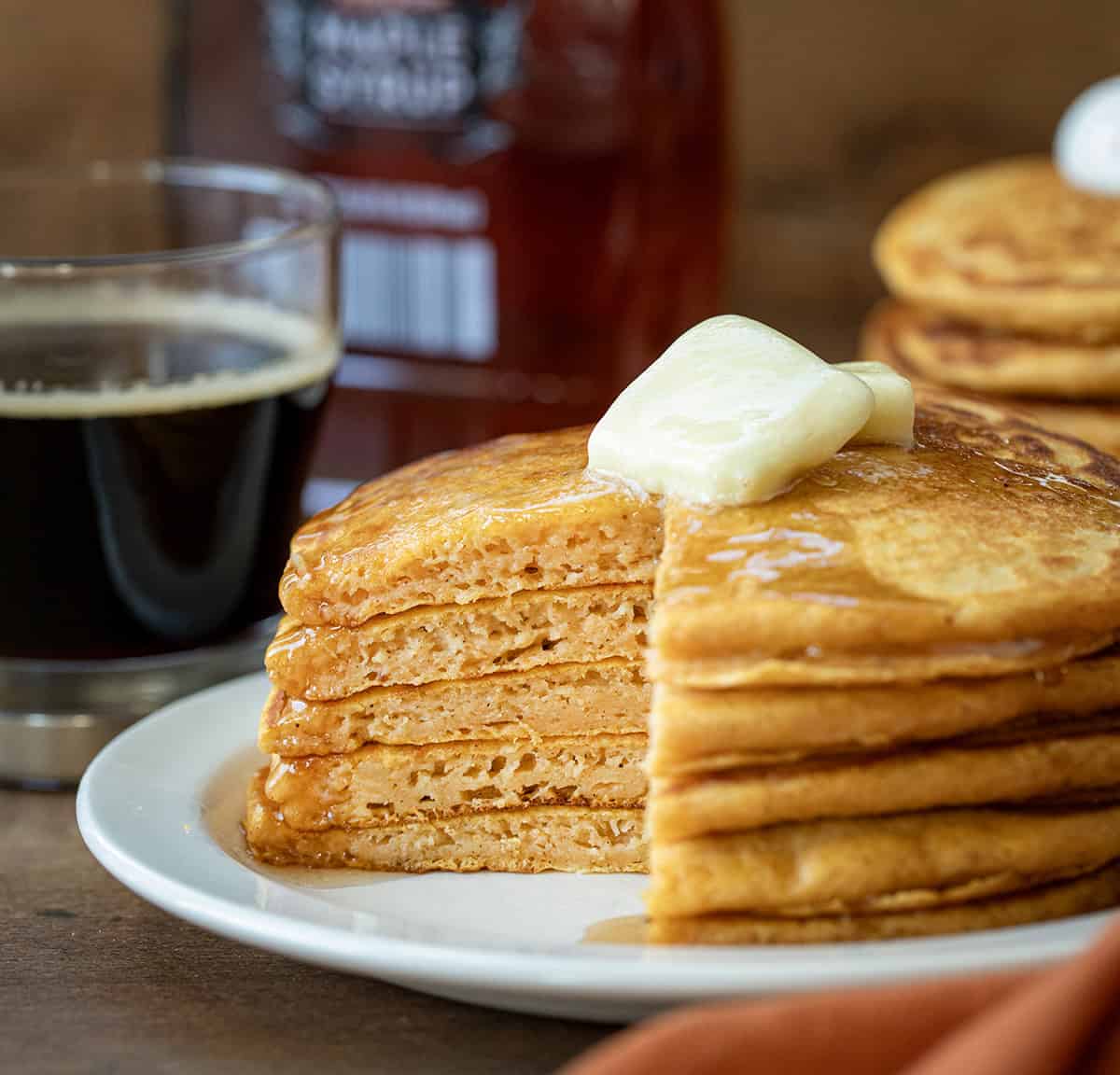 Cut-into stack of Sweet Potato Pancakes on a white plate showing the inside texture.