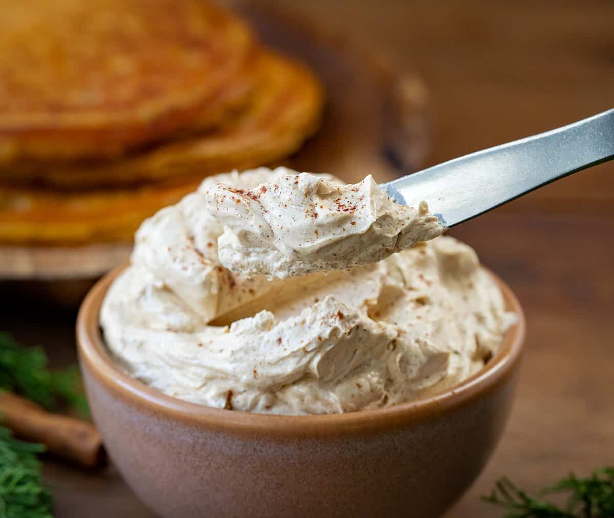 Knife taking a dollop of Whipped Gingerbread Butter from a bowl.