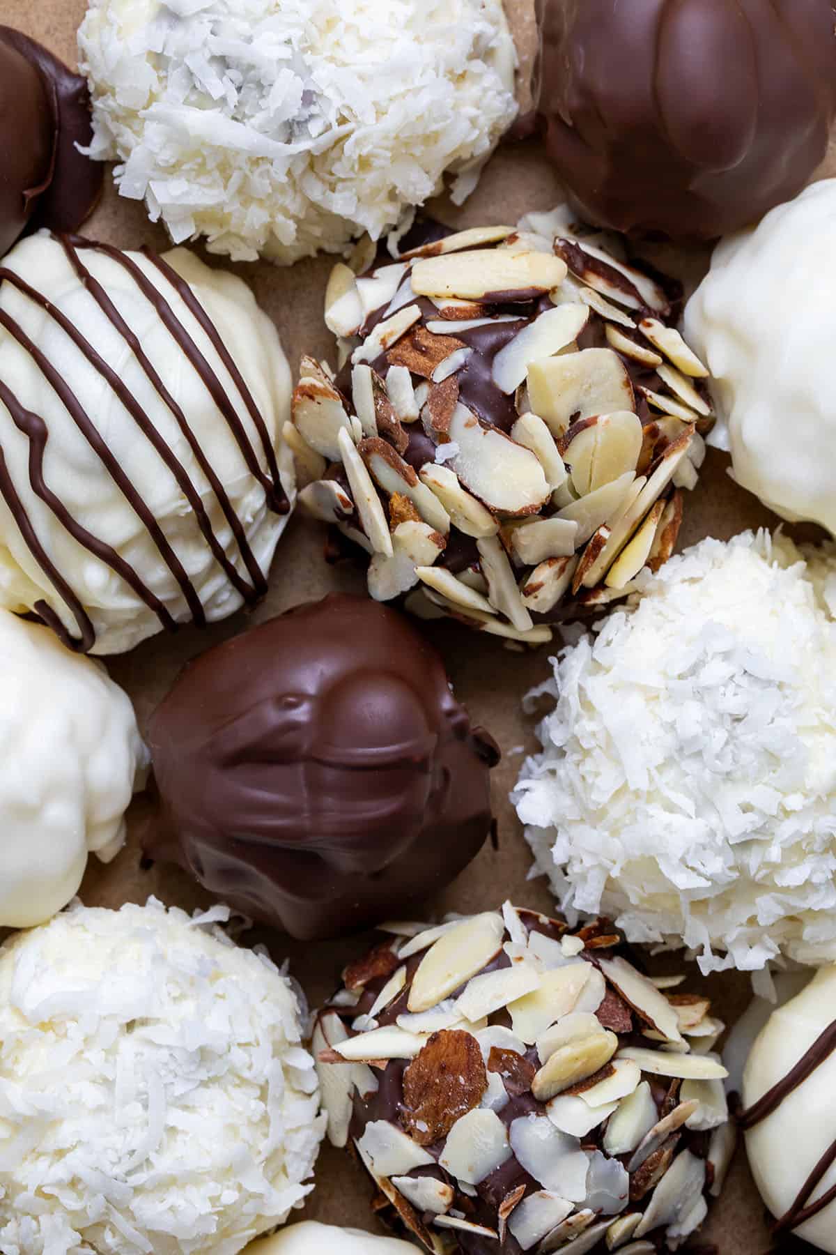 Almond Joy Truffles on a piece of parchment paper very close together and very close to the truffles.