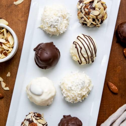 White tray of Almond Joy Truffles on a wooden table from overhead.