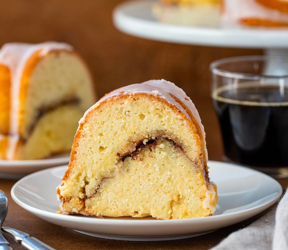 Slice of Cinnamon Swirl Bundt Cake on a white plate.