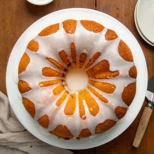 Cinnamon Swirl Bundt Cake on a cake platter on a wooden table from overhead.