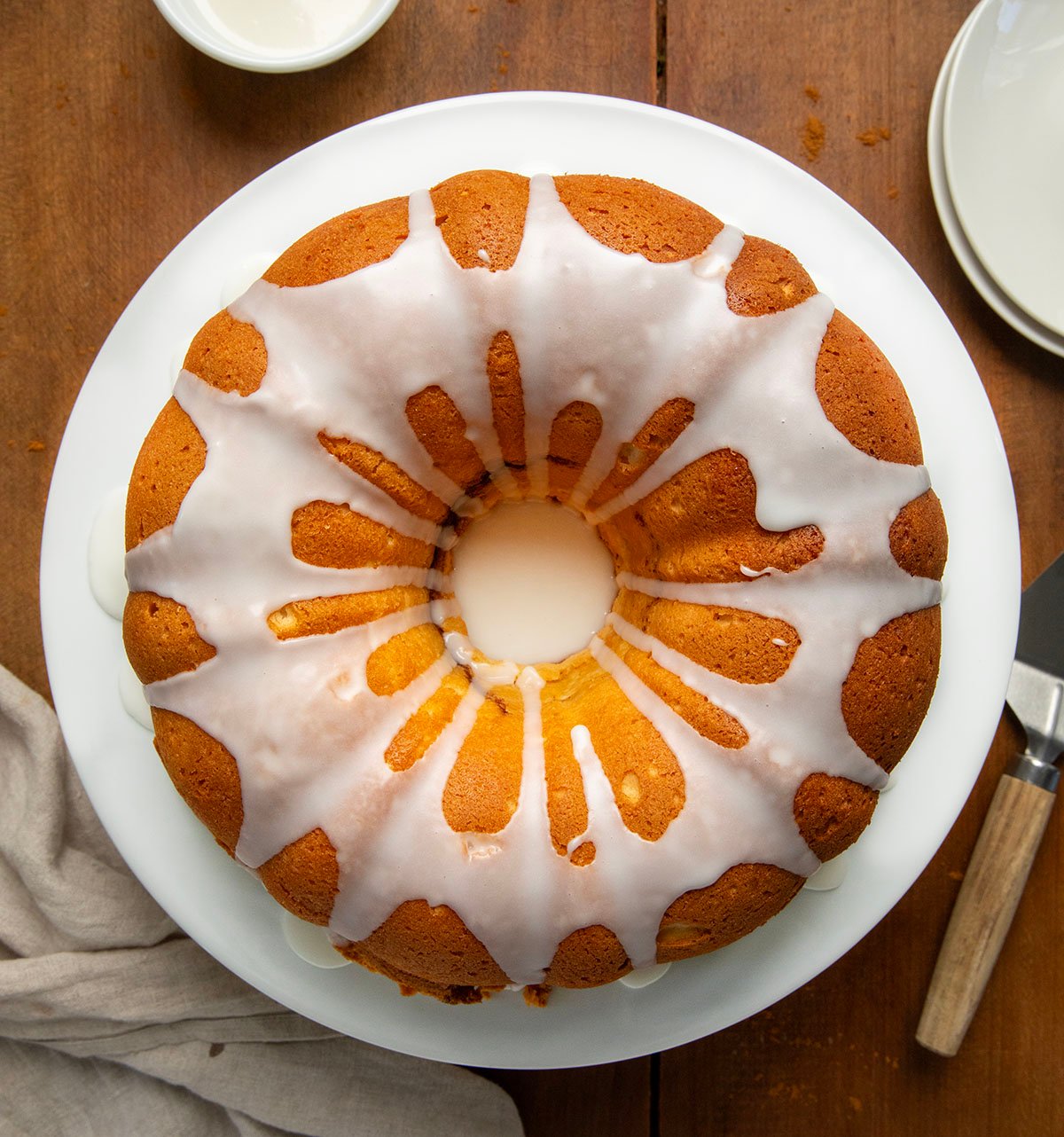 Cinnamon Swirl Bundt Cake on a cake platter on a wooden table from overhead.