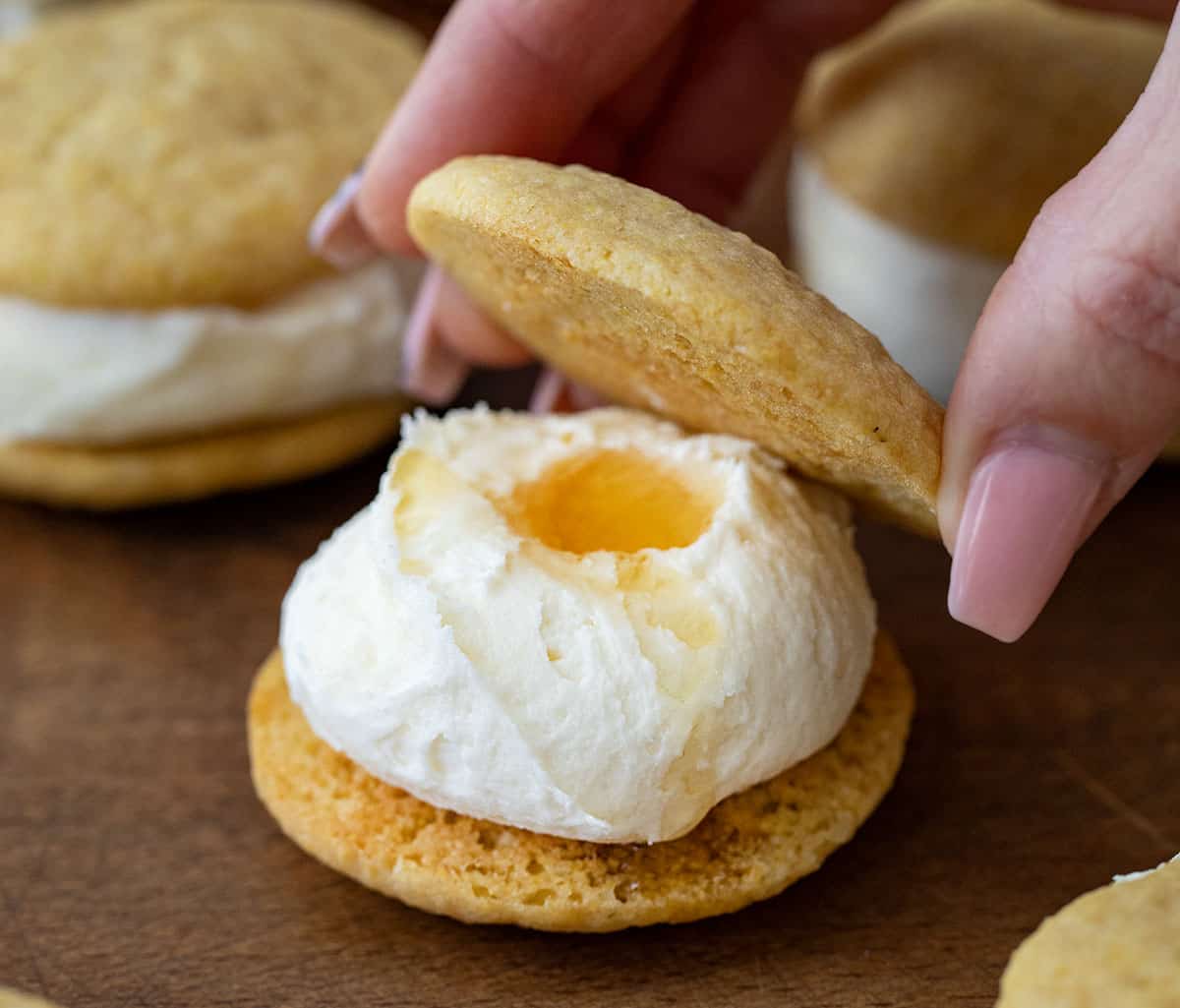 Assembling a Cornbread Sandwich Cookies with honey nestled into the frosting.