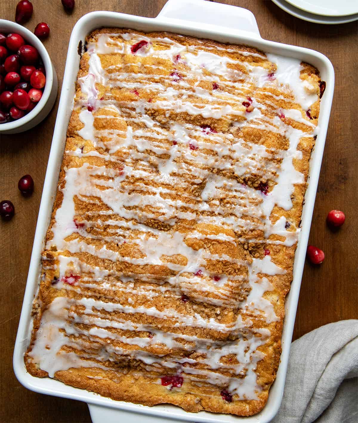 Pan of Cranberry Coffee Cake on a wooden table with fresh cranberries. 