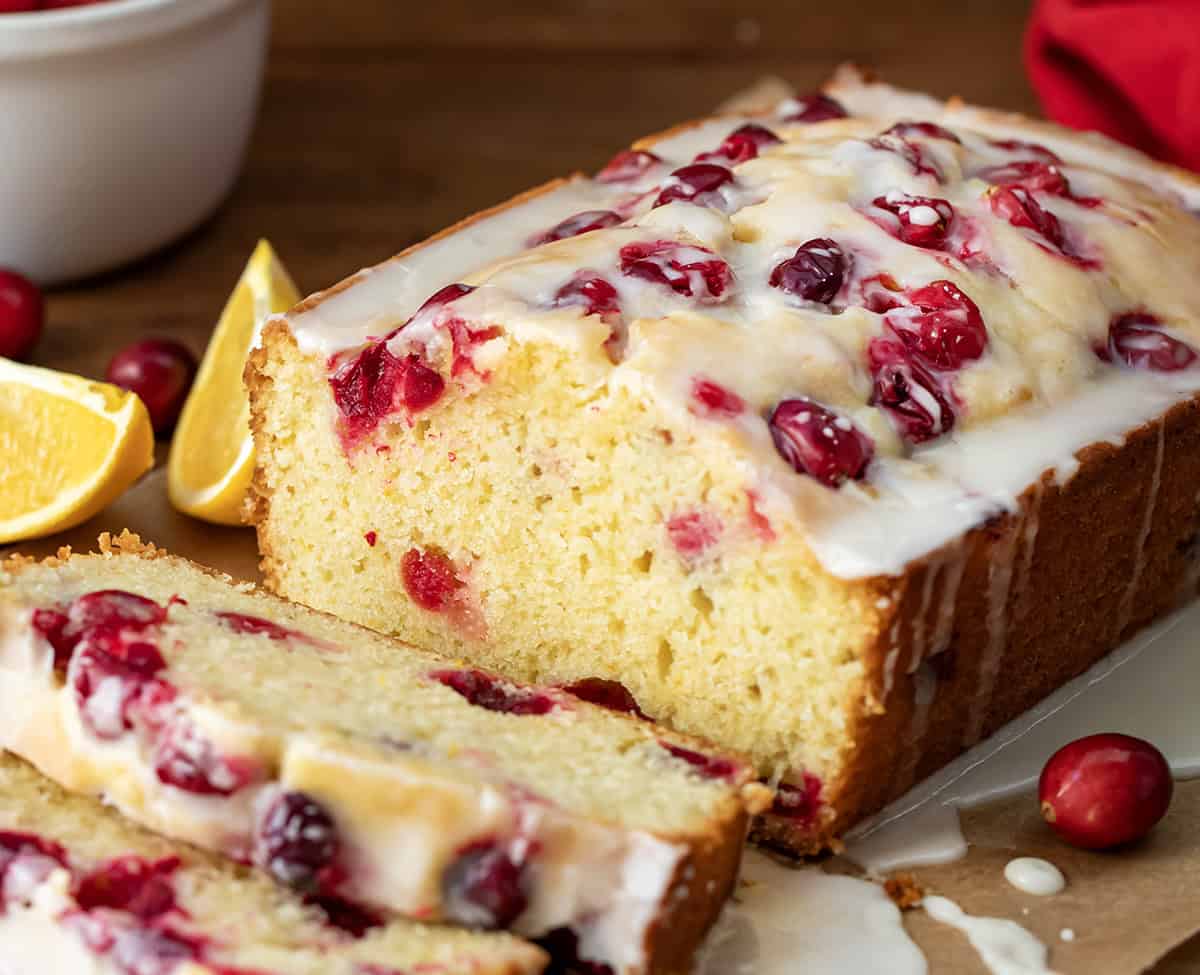 Cranberry Orange Loaf on a table with a few pieces cut off and laying flat.