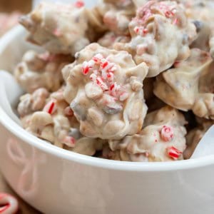 Bowl of Crockpot Christmas Candy surrounded by peppermint candy canes.