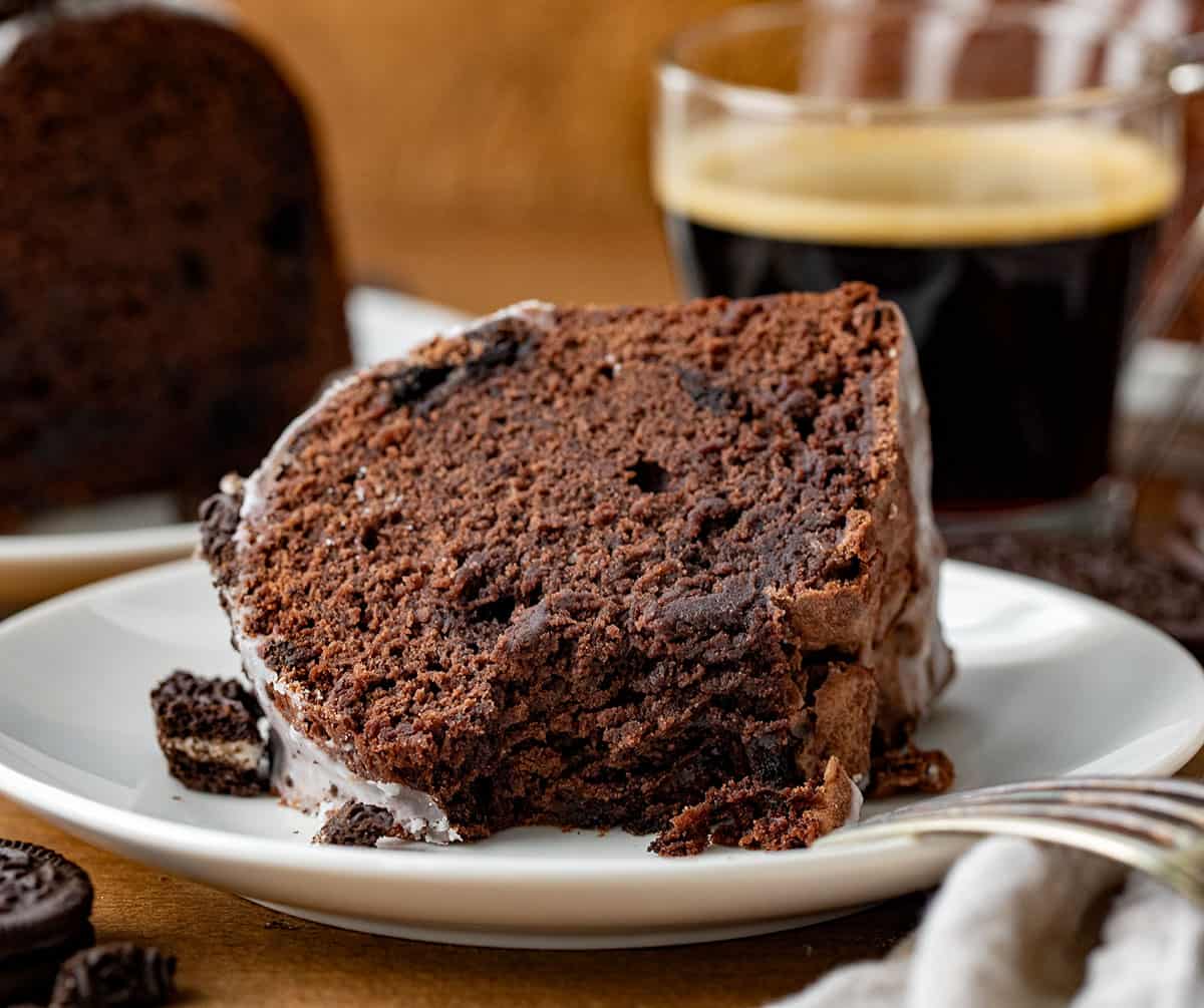 Piece of Oreo Bundt Cake on its side on a white plate with a bite taken out.