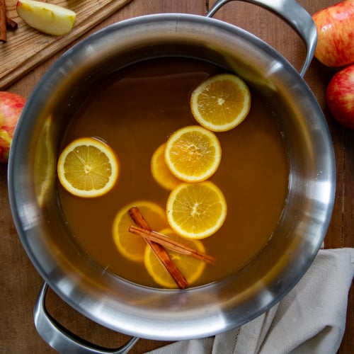 Pot of Spiked Apple Cider on a wooden table from overhead.