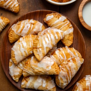 Sweet Potato Hand Pies on a wooden plate on a wooden table from overhead.