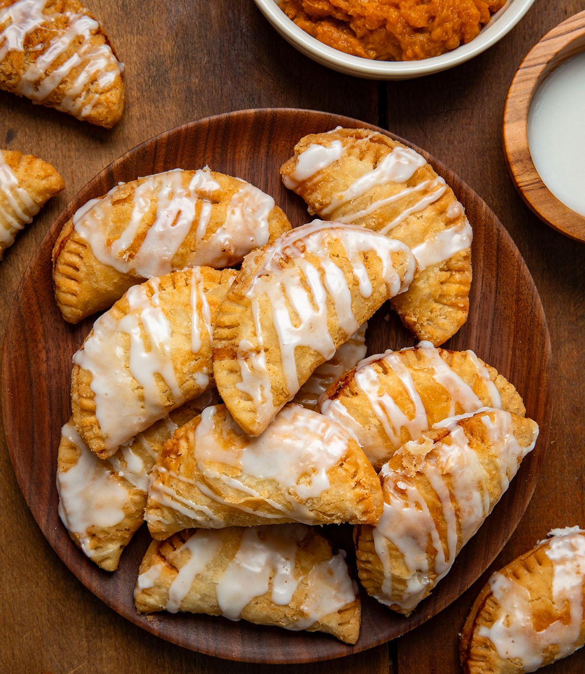 Sweet Potato Hand Pies on a wooden plate on a wooden table from overhead.