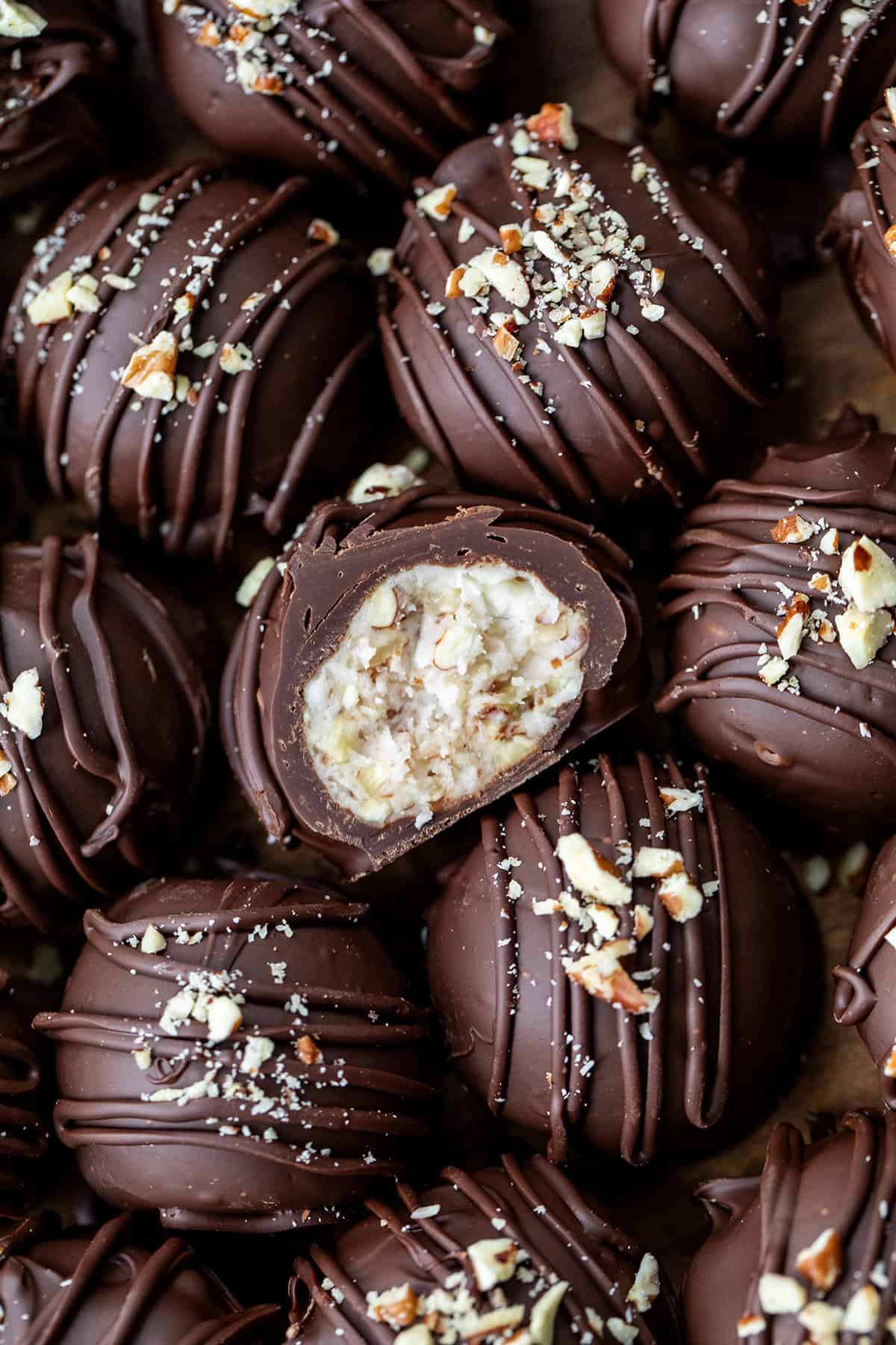 Bourbon Balls very close together and with the center bourbon ball cut in half showing the inside texture.