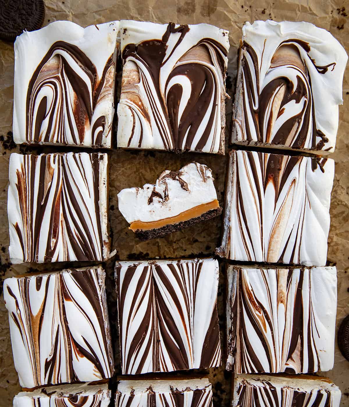 Caramel Marshmallow Bars cut into squares with the center square turned on its side showing the layers. 