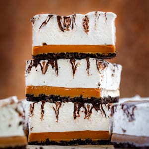 Stack of three Caramel Marshmallow Bars on a wooden table.