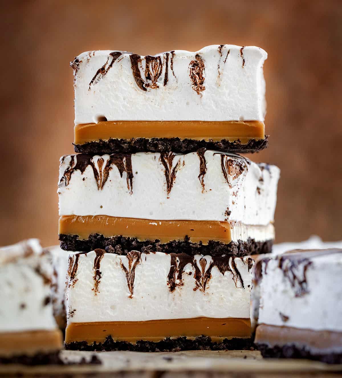 Stack of three Caramel Marshmallow Bars on a wooden table.