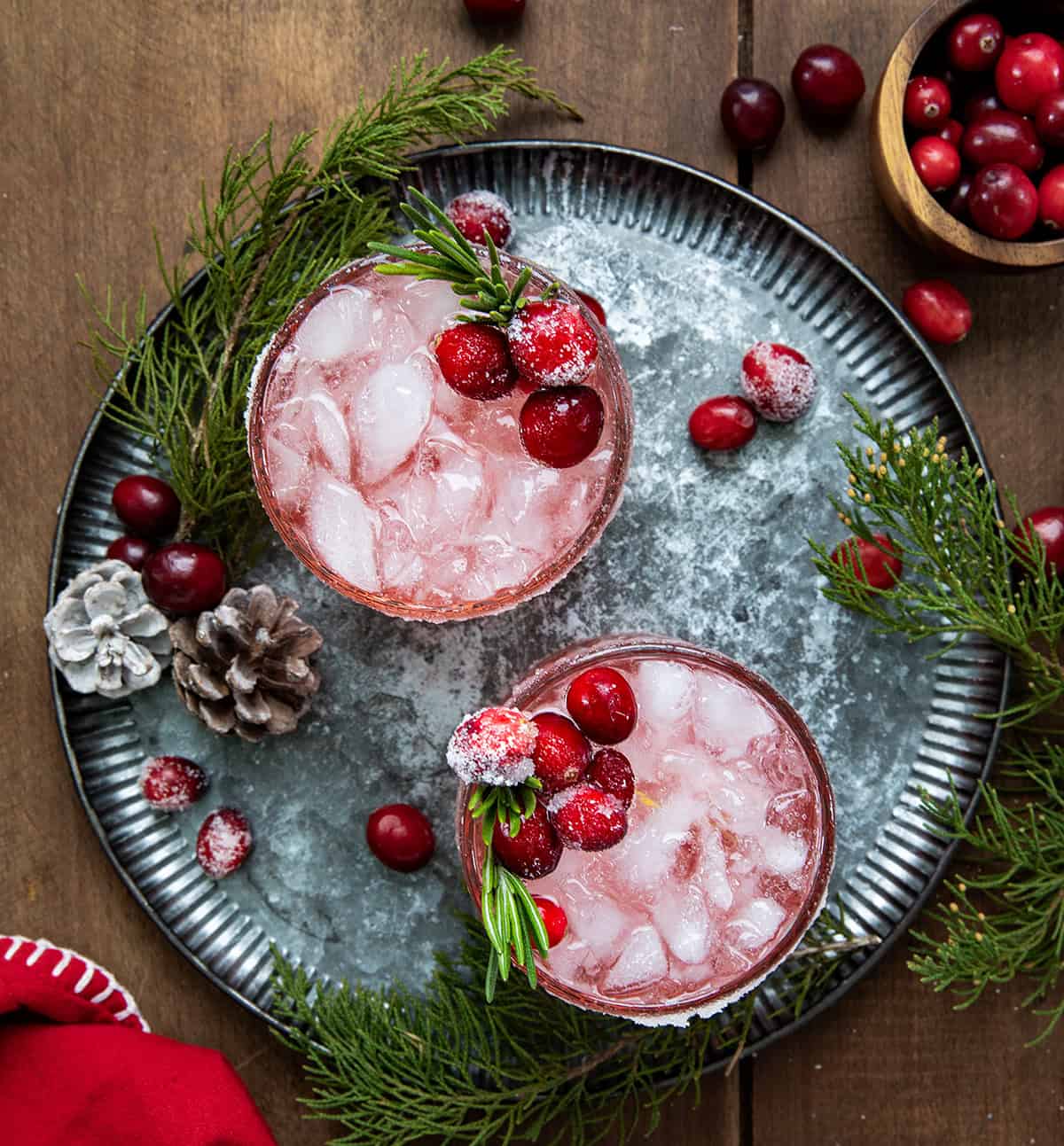 Glasses of Christmas Gin Fizz on a tray on a wooden table from overhead.