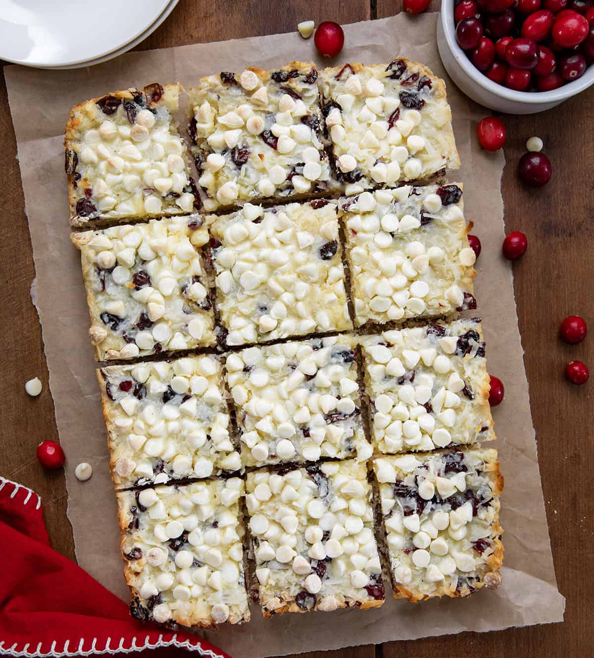 Cranberry White Chocolate Magic Bars cut into square bars on a wooden table from overhead.