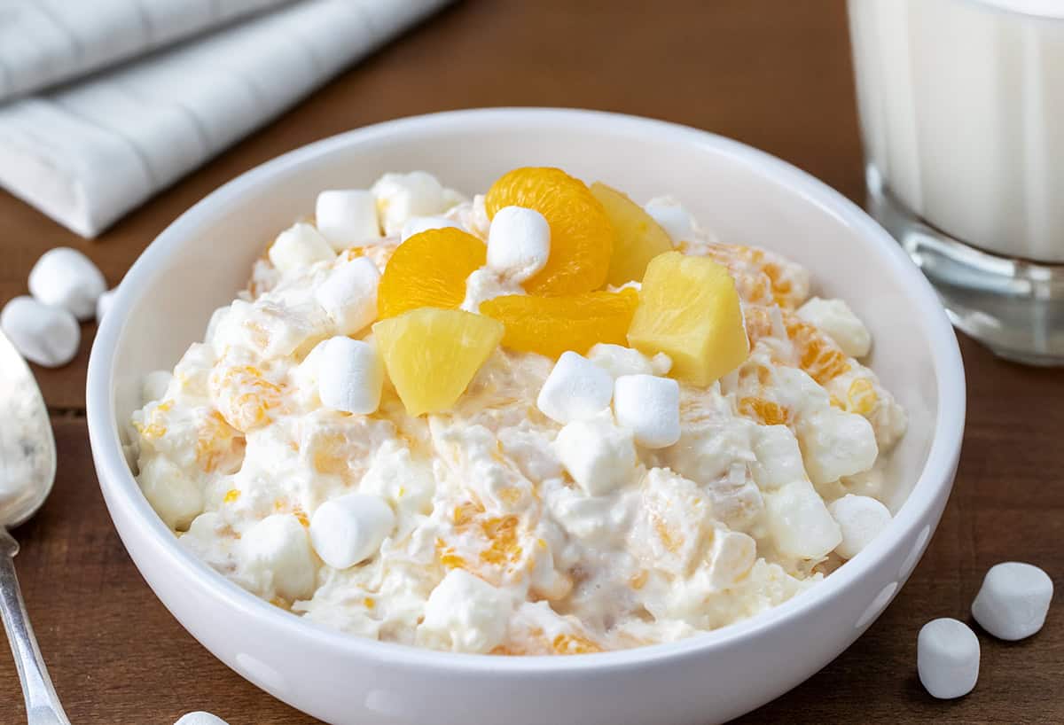 White bowl of Five Cup Salad on a wooden table.