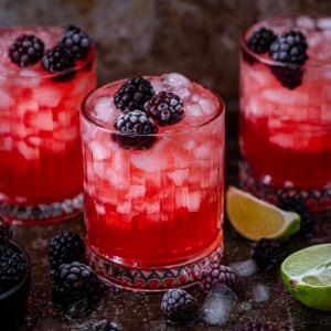 Glasses of Frosted Blackberry Bourbon Smash with frosted blackberries.