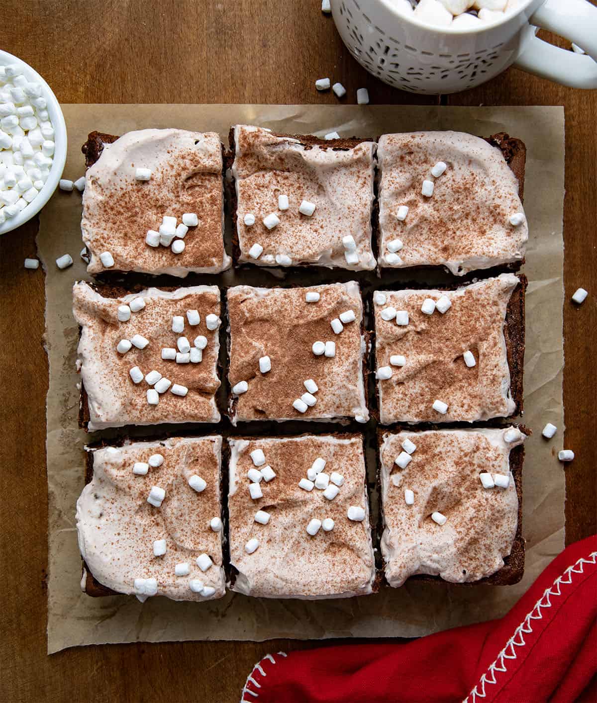 Hot Chocolate Cheesecake Bars cur into squares on a piece of brown parchment from overhead.