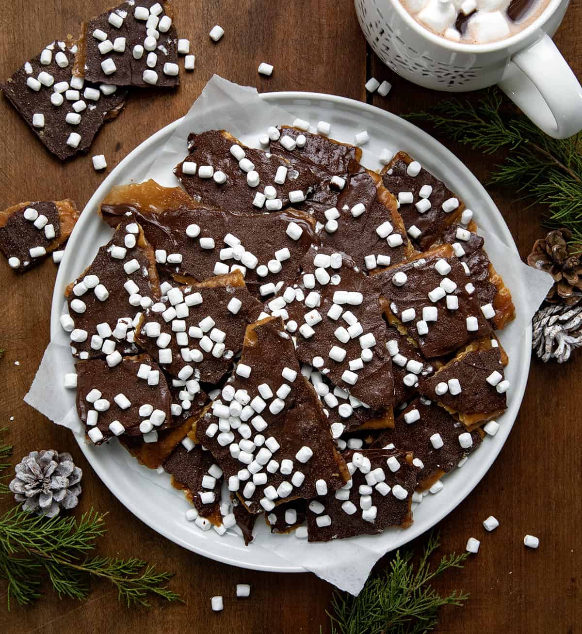 Plate of Hot Cocoa Christmas Crack on a white platter on a wooden table from overhead.