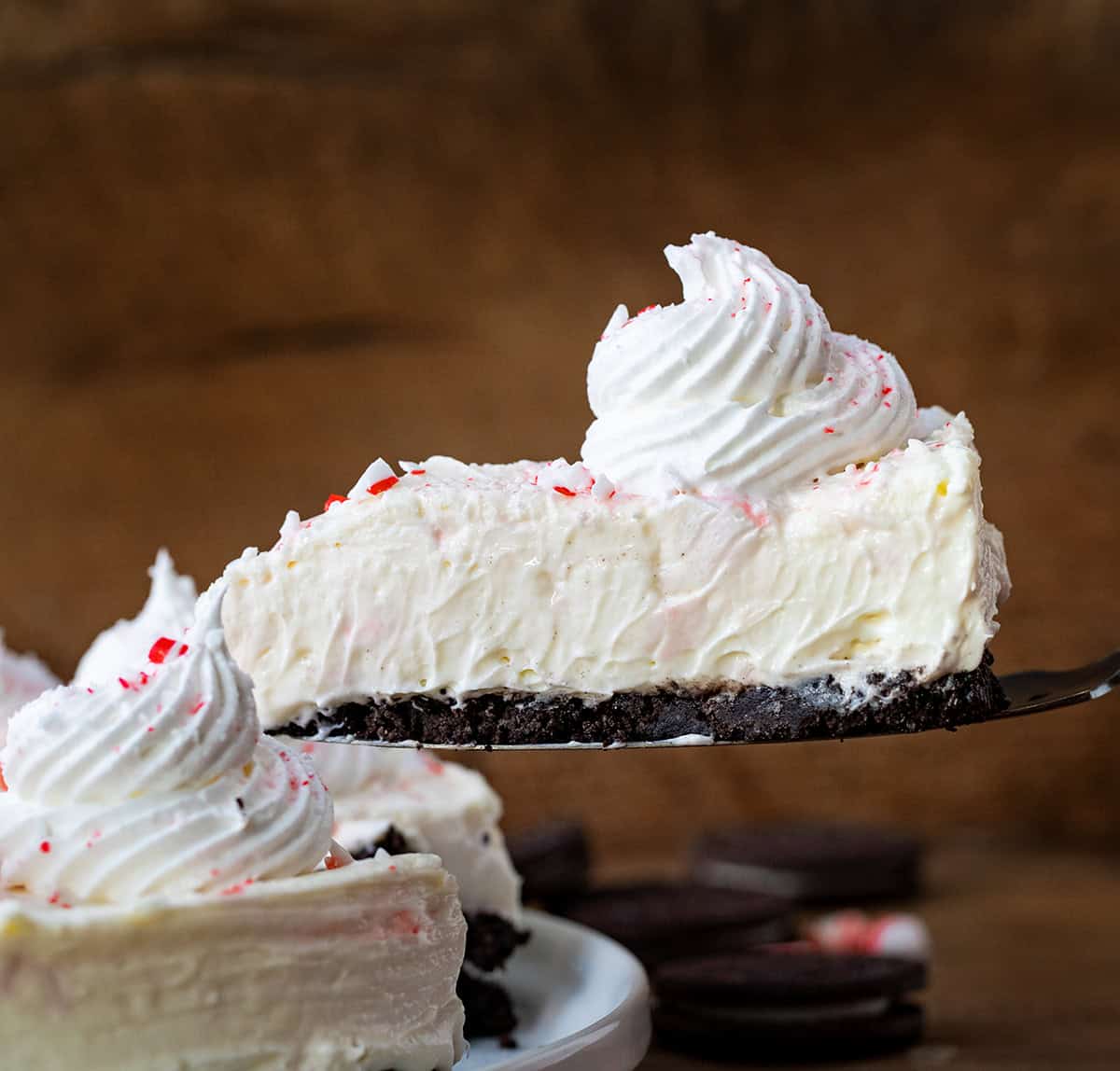 Picking up a piece of No Bake Peppermint Cheesecake from the platter.