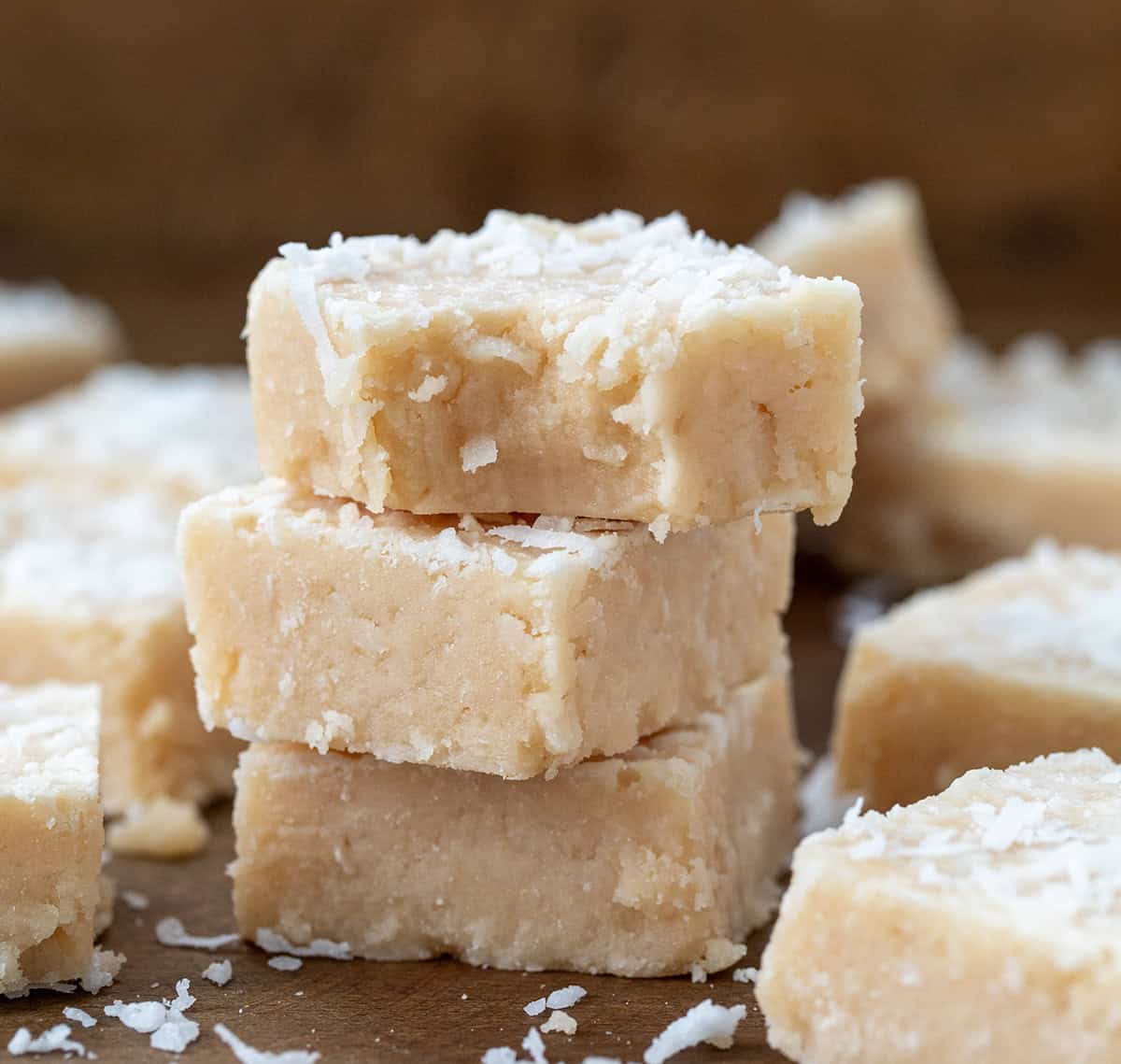 Stack of White Coconut Fudge with top piece with a bite taken out of it.