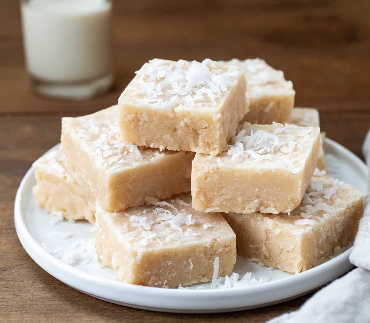 Plate of White Coconut Fudge on a wooden table close up.