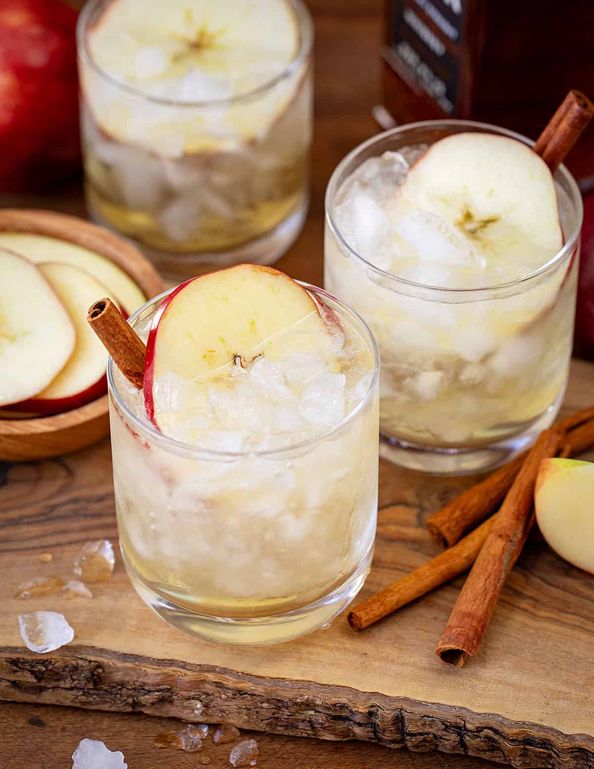 Glasses of Apple Bourbon Milk Punch on a wooden cutting board.