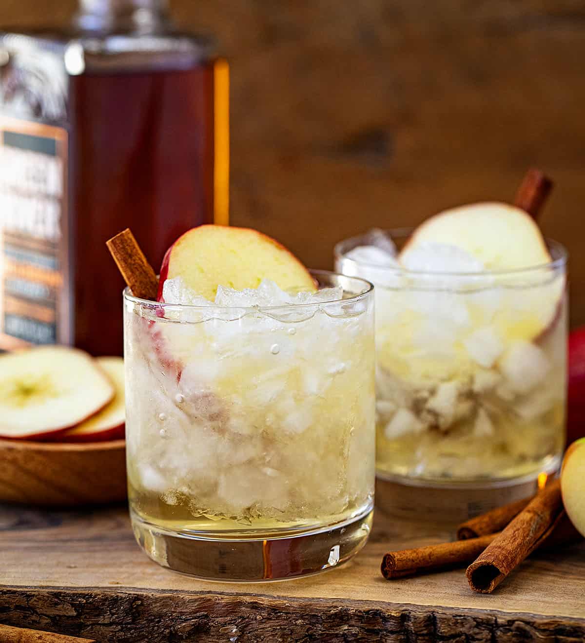 Glasses of Apple Bourbon Milk Punch on a wooden cutting board.