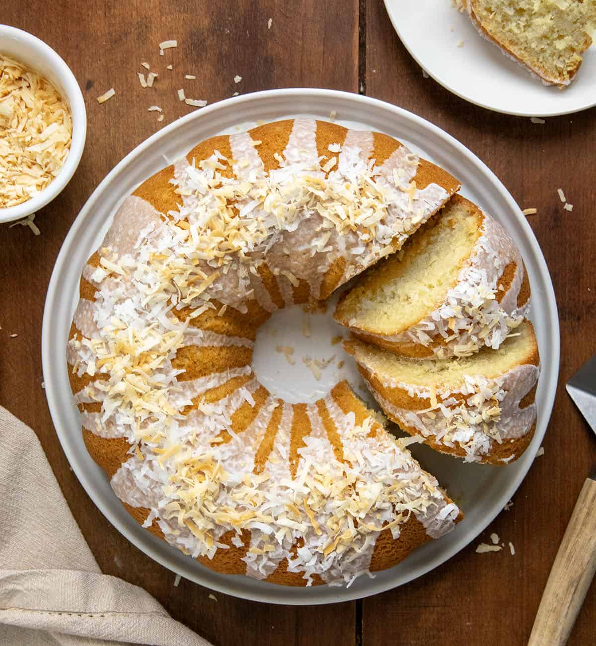 Coconut Pound Cake on a white platter with some pieces cut and on their side. 