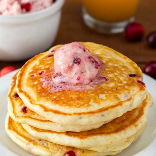 Stack of pancakes with Cranberry Honey Butter melting on top.