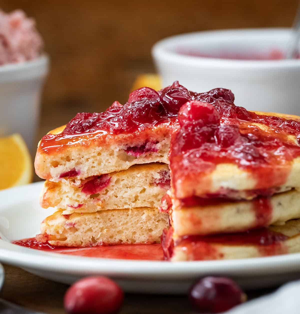 Stack of Cranberry Orange Buttermilk Pancakes that have been cut into showing thickness and tender texture.