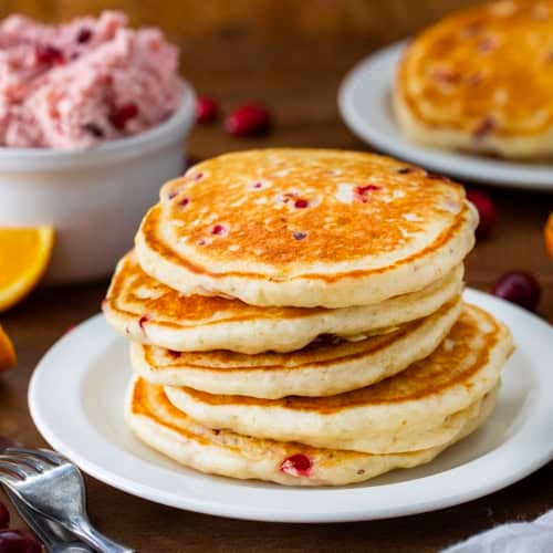 Stack of Cranberry Orange Buttermilk Pancakes on a white plate.