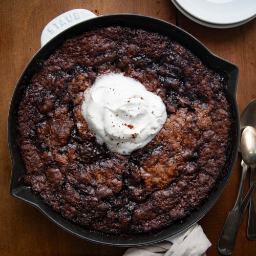 Skillet of Hot Fudge Pudding Cake on a wooden table from overhead.