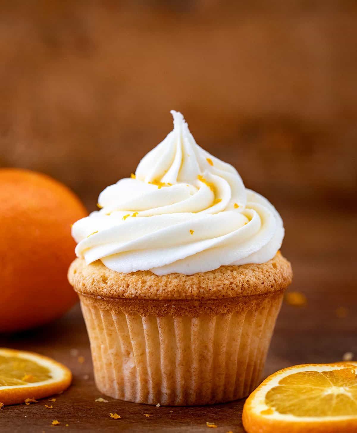 Cupcake with Orange Creamsicle Buttercream piped on top with fresh orange slices.