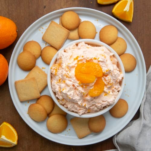 Bowl of Orange Creamsicle Dream Dip on a white platter with vanilla wafers from overhead.