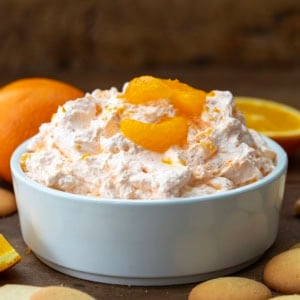 White bowl full of Orange Creamsicle Dream Dip on a wooden table.