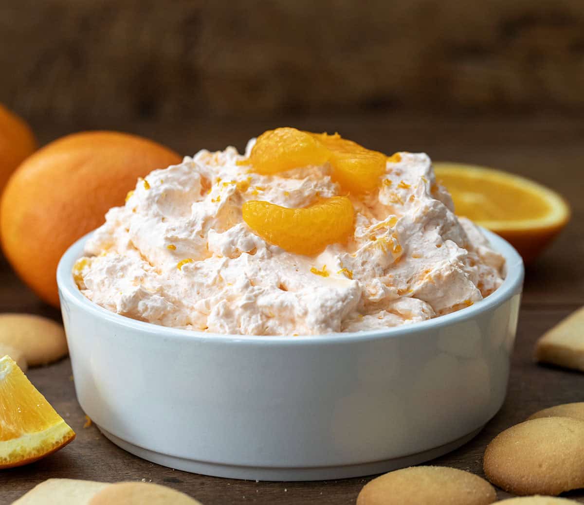 White bowl full of Orange Creamsicle Dream Dip on a wooden table.