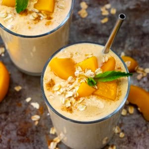 Peach Cobbler Smoothies on a tray with straws.