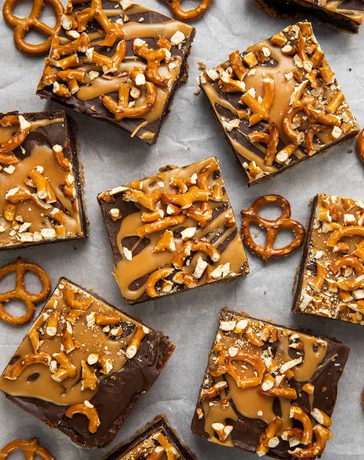 Cut up Salted Caramel Pretzel Brownies on parchment paper with pretzels from overhead. 