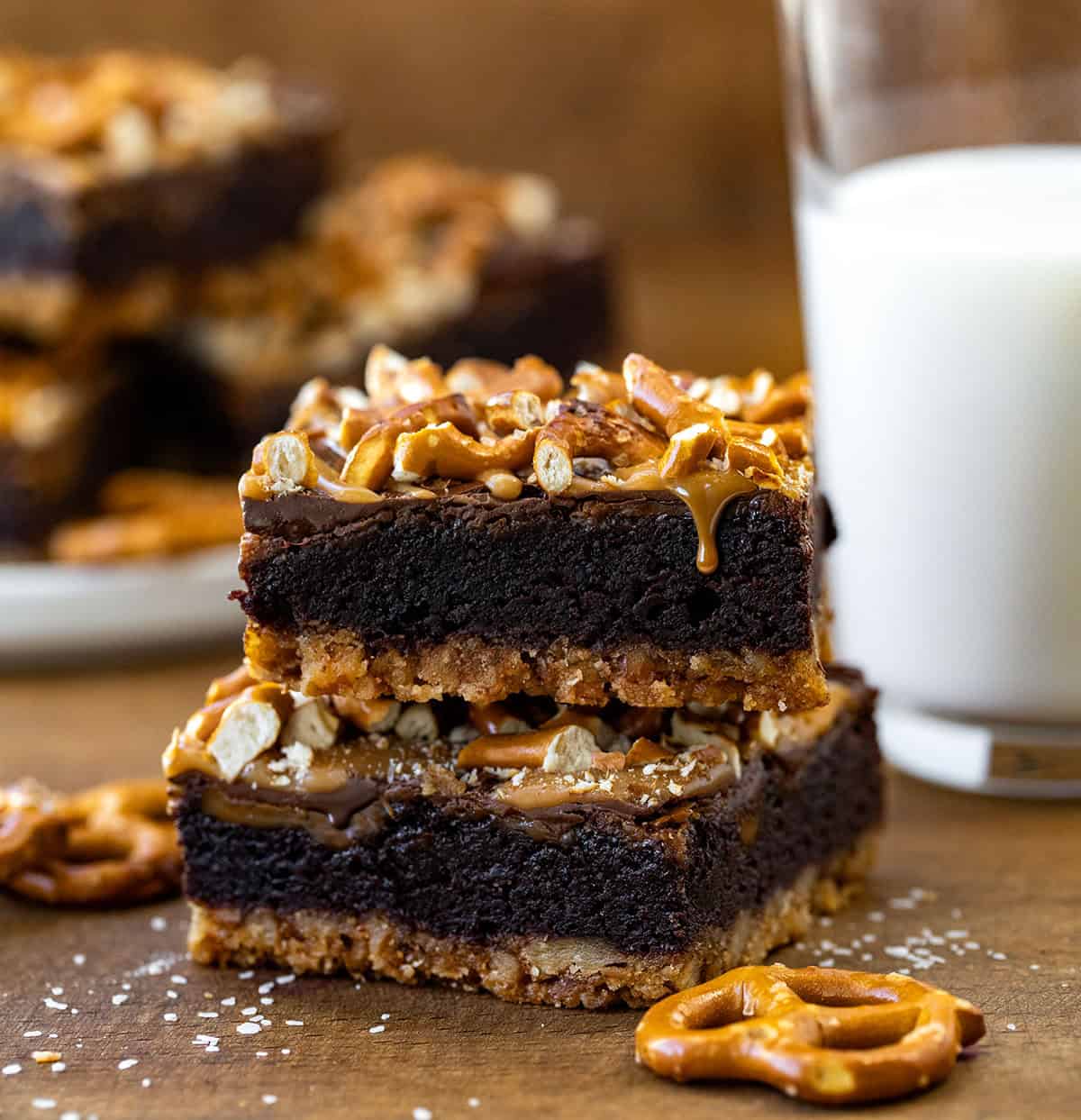 Salted Caramel Pretzel Brownies stacked with caramel dripping.