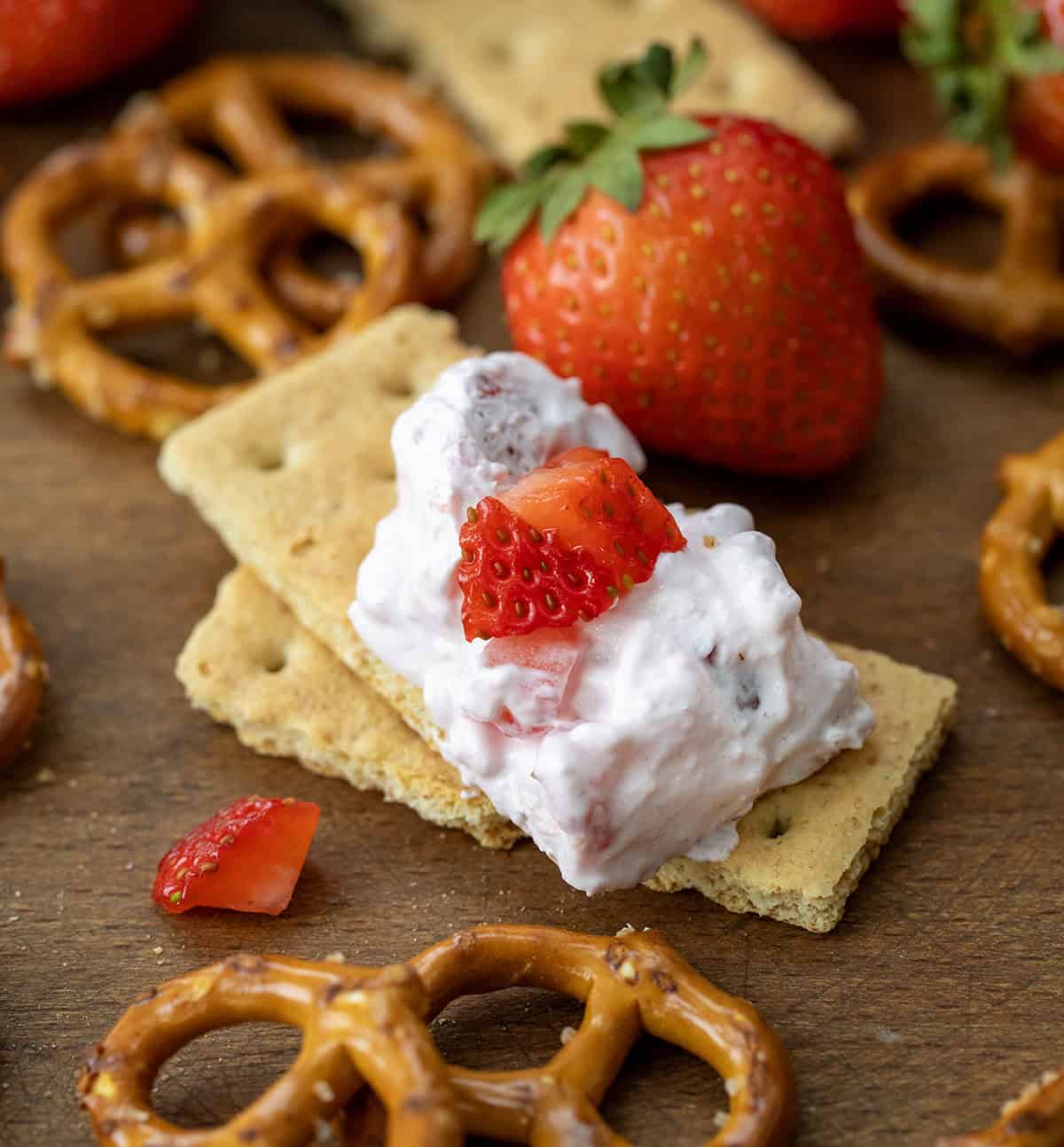 Graham crackers with Strawberry Dream Dip on it with fresh strawberries and pretzels.