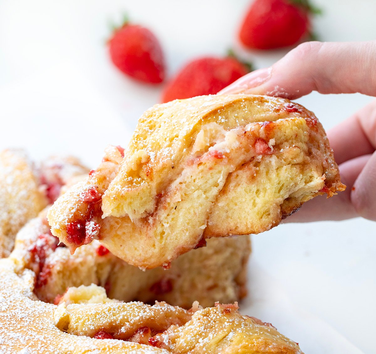 Hand holding a Strawberry Heart Bread piece.