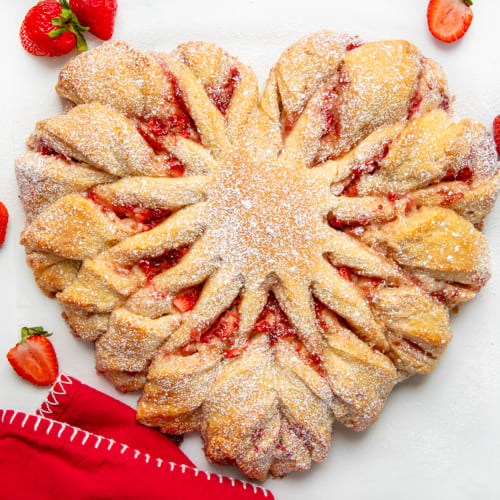 Strawberry Heart Bread on a white counter with strawberries and a red napkin.