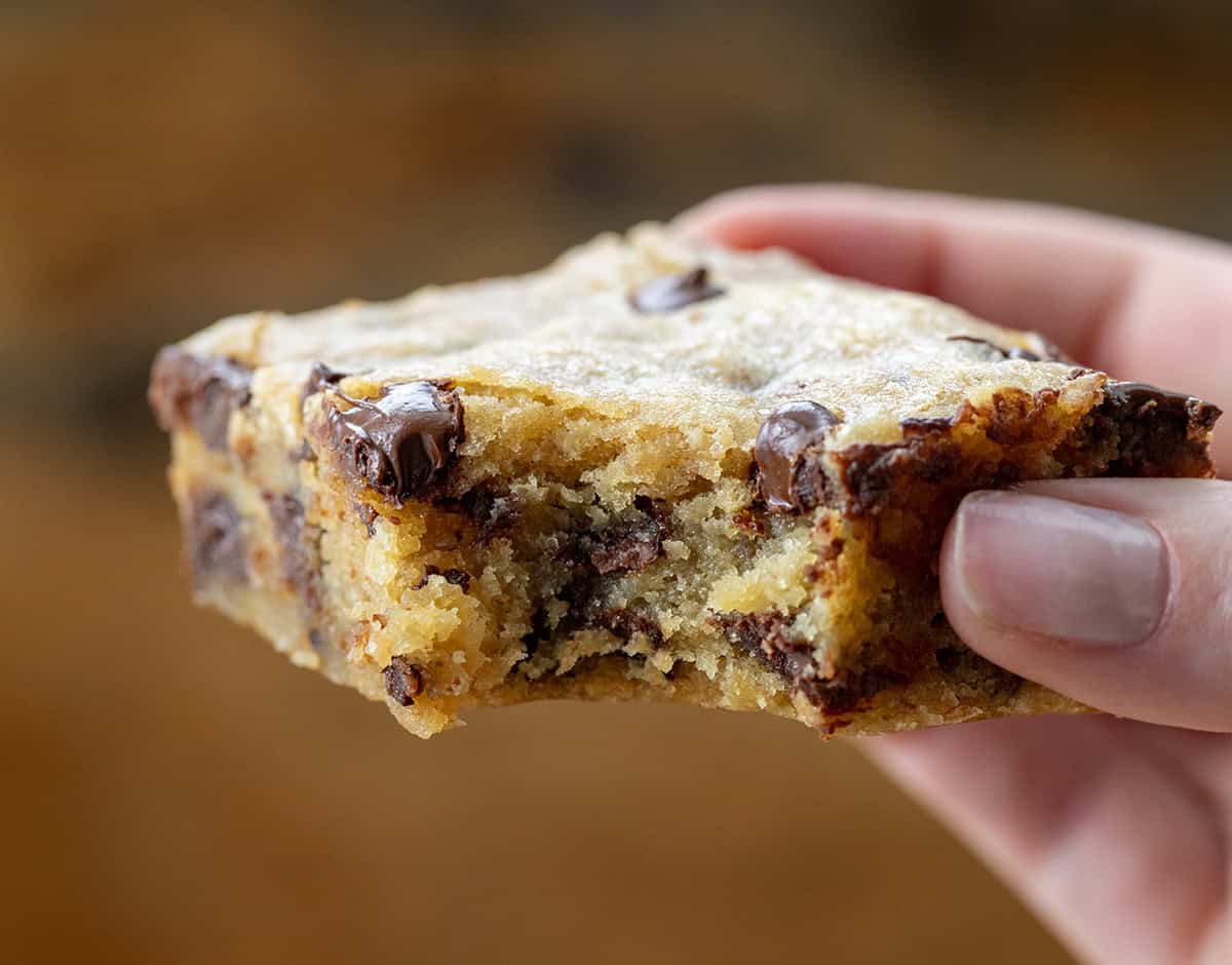 Hand holding a Banana Chocolate Chip Bars with a bite taken out of it.